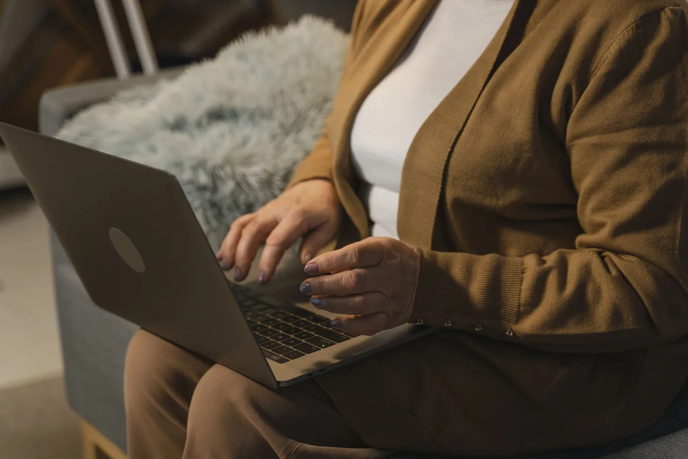 Nahaufnahme einer Person, die zu Hause einen Laptop benutzt.